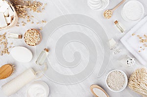 Handicraft natural cosmetics - white cream, oil, towel and bath accessories on soft light white wood table, frame, flat lay.