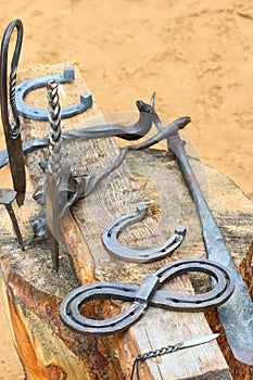 Handicrafts knives, horseshoes on wooden stump