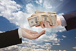 Handing Over Cash with Dramatic Clouds and Sky