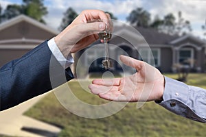 Handing Over the House Keys in Front of a Beautiful New Home.