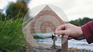 Handing over the keys next to the wooden house model.