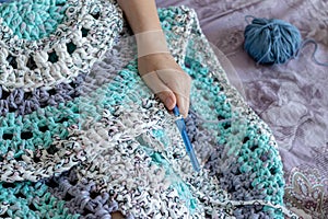 Handiwork. Knitting. Handmade. Girl crocheting floor Mat