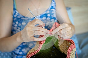 Handiwork. Knitting. Handmade. A girl crochets a colored bag