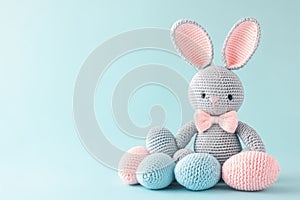 Handknitted bunny toy with pastel Easter eggs around it