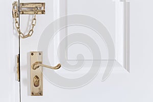 Handle and chain on the white front door