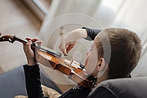 Handle hold violin. Little boy carrying violin. Young boy playing violin, talented violin player