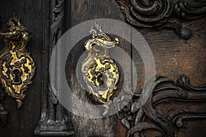 Handle and keyhole of an old wooden door decorated with handmade decor
