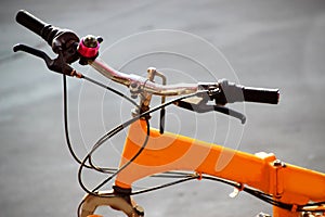 Handlebar and frame of yellow bike on concrete road background