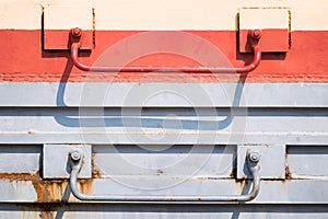 Handles on the side of an old rusty railroad car.