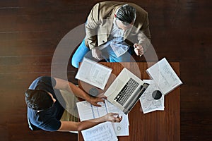 Handling all their business matters together. High angle shot of two businessmen having a meeting in an office.