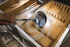 Handling a big stainless steel ladle out of the storage contain