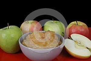 Handmade apple jam and fresh apples on black background