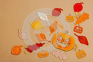 Handmade autumn background. Set of different fall knitted and crocheted fall leaves and wooden pumpkins