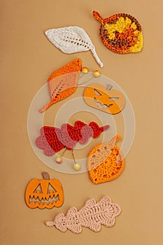 Handmade autumn background. Set of different fall knitted and crocheted fall leaves and wooden pumpkins