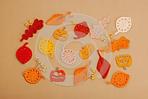 Handmade autumn background. Set of different fall knitted and crocheted fall leaves and wooden pumpkins