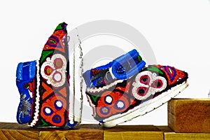 Handmade baby shoes,Embroidery shoes on wood and white background,gujrati Embroidery,baby shoes on wooden box