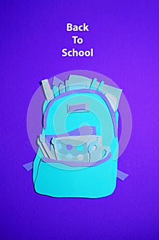 The handmade backpack with school accessories was cut out of blue, purple paper