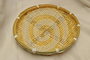 Handmade bamboo sieve with green crosshatching pattern. Storage basket