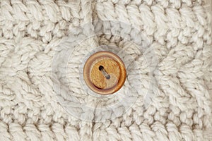 Handmade beige knitted Fabric Texture with wooden button