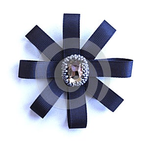 Handmade brooch from dark blue tapes and a rhinestone