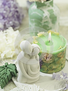 Handmade candles of a unique design, with different flowers, dry leaves on a light background. Candles made from organic