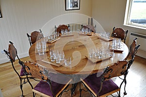 Handmade chairs and round dining room table with degustation sets photo