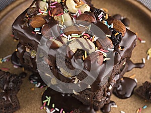 Handmade chocolate cake with nuts and raisins in a ceramic plate.