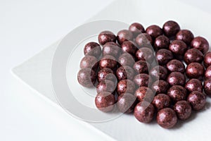 Handmade chocolate candy on white plate close-up. Tasty luxury dessert. Chocolatier sweet shop business concept