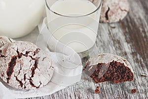 Handmade chocolate cookies, glass and jug with milk, blurred background