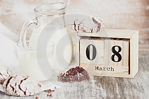 Handmade chocolate cookies, glass and jug with milk, blurred background
