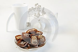 Handmade chocolate covered with cocoa and nut crumbs. Still life with sweets and tea appliances. Copy space