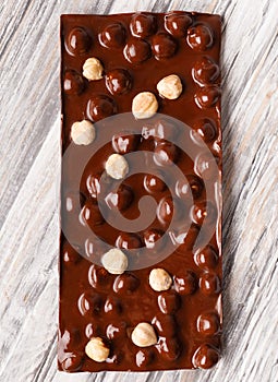 Handmade chocolate with hazelnuts on a gray wooden background, close-up