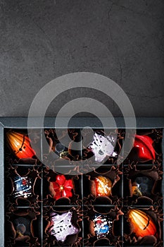 Handmade chocolates in a box on a dark background.