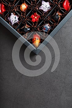 Handmade chocolates in a box on a dark background.