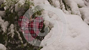 Handmade Christmas Decoration hanging on snowy fir tree