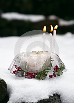 Handmade Christmas lantern in shape of cake made of ice, red rose hips berries, holly berry branches