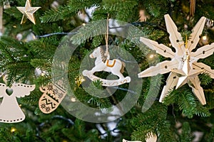 Handmade Christmas tree decoration hanging on tree with balls and wooden toys. Christmas zero-waste ornaments. wooden