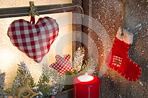 Handmade Christmas wooden window decoration with heart and a red santa boot