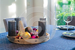 Handmade Christmas wreath from a wooden bowl filled with colorful balls and dark candles