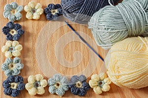 Handmade colorful crochet flower with skein on wooden table