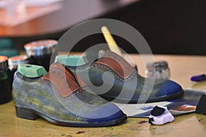 Handmade colorful luxury man shoes are hand-painted in a production factory. photo