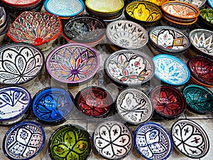 Handmade colourful decorated bowls or cups on display at traditional souk - street market in Morocco