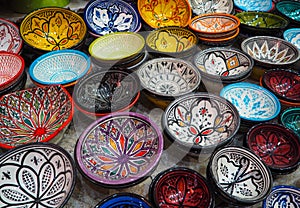 Handmade colourful decorated bowls or cups on display at traditional souk - street market in Morocco