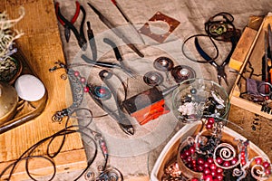 Handmade copper wire working tools on the table with accessoires. handicraft people art concept
