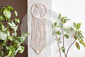 Handmade cotton macrame Dream catcher on white wall background. Traditional amulet for protecting sleep.  Macrame lace on the wall