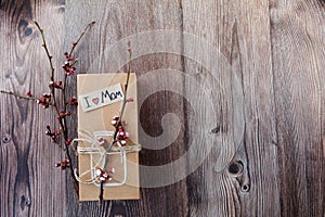 Handmade craft box gifts with painted vase and bouquet of spring branches and flowers on wooden background and text I love mom.