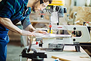 Carpenter engaged in processing wood at the sawmill.