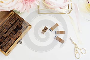 Handmade, craft concept. Wooden rubber stamps, golden scissors, ribbons. Feminine workplace concept. Freelance fashion femininity