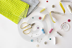 Handmade crafting and sewing. Fabrics, scissors, threads and accessories for sewing on a white background. Flat lay