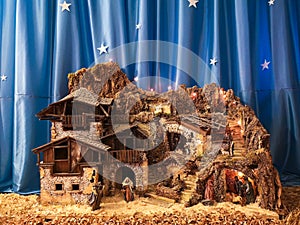 Handmade crib nativity scene. In the background starry silk sky